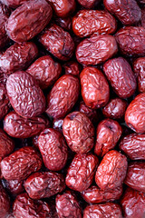 Macro shot of a pile of dried red jujubes.