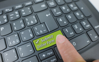 Submit online form key on a gray keyboard. Finger pressing key
