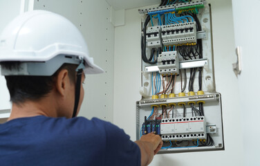Electrician working checking a switchboard with fuses