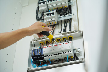 Electrician working checking a switchboard with fuses