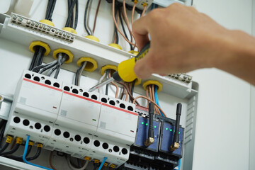 Electrician working checking a switchboard with fuses