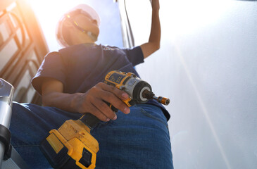A technician installs a CCTV camera on the facade of a residential building