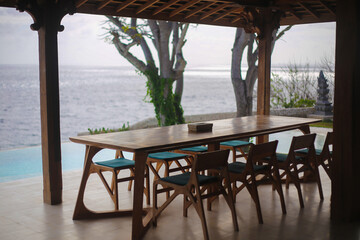 Wooden Dining Set on Open Terrace Overlooking Infinity Pool and Ocean