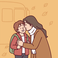 Mother gently adjusts scarf of child while saying goodbye before school bus ride on a chilly autumn morning