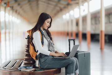 Woman Working on Laptop at Train Station