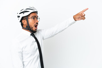 Young business latin man holding a bike helmet isolated on white background pointing away