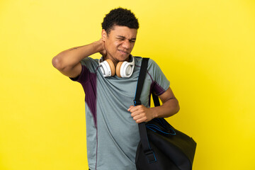 Young sport African American man with sport bag isolated on yellow background with neckache