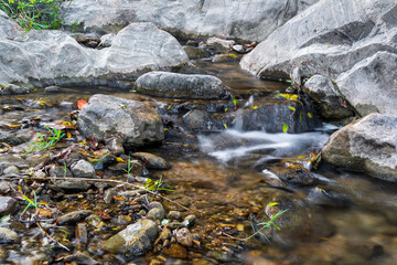 closeup waterfall stream with rocks stones on nature clear motion flow water in autumn natural...