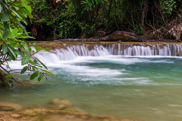 waterfall clear emerald flow motion water with nature pool pond and stream algae on summer season for fresh relax on green trees in natural forest garden at huai mae khamin waterfall national park