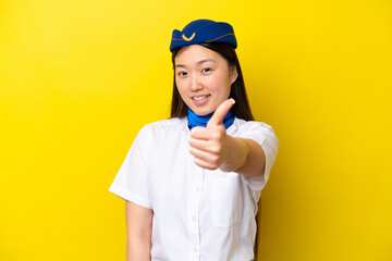Airplane Chinese woman stewardess isolated on yellow background with thumbs up because something...