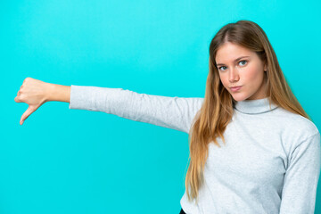 Young blonde woman isolated on blue background showing thumb down with negative expression