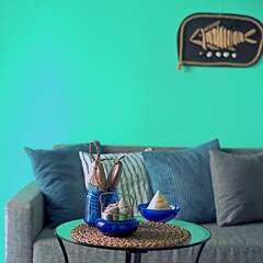 Marine style in the apartment interior - a sofa with pillows and a table with shells and fish figures.