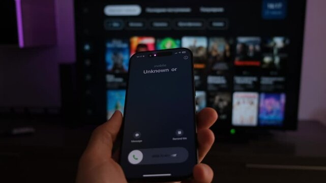 Fraud or fraudulent schemes. Close-up of a male hand holding a phone with an unexpected incoming call from an unknown