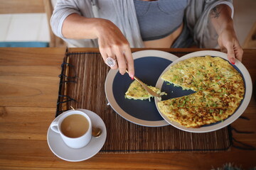 Woman Serving Herself Omelette at Breakfast with Coffee