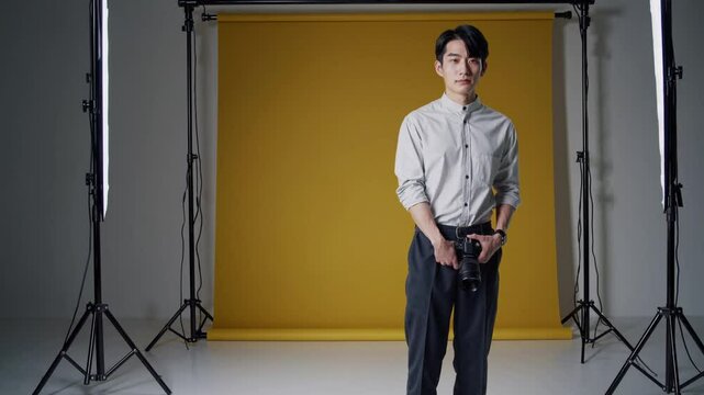 Behind the Lens: A photographer stands confidently in a studio setting, ready to capture the world through their camera, backlit by professional lighting equipment.