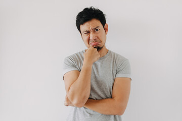 Asian man thinking with hand on chin and doubtful facial expression