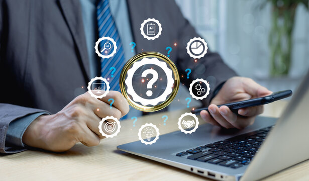 Root cause analysis concept, Businessman hand holding magnifying glass over large question mark surrounded by smaller ones, symbolizing investigation, problem-solving, and solution discovery.