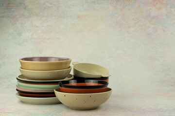 Ceramic and plastic food plates on an abstract background. There is space for text. Tableware in the form of plates stacked in a stack.