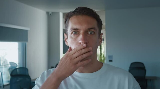 Surprised man lowering glasses in disbelief while working from home, showcasing shock and amazement in his home office, capturing moment of unexpected reaction and emotion. Surprise in man