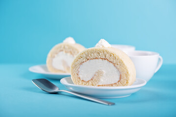 Vanilla cake roll with whipped cream filling in a plate