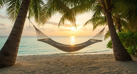 Hammock hanging between palm trees on tropical beach at sunset