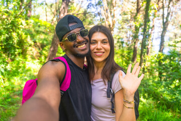Hikers taking selfie and waving in forest