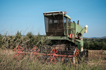 Green combine harvester standing on a field in day time