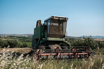 Green combine harvester standing on a field in day time