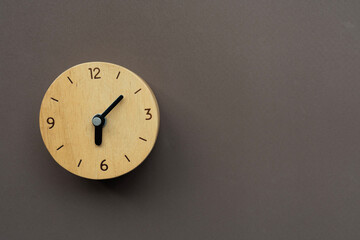 Retro alarm clock on brown table background, vintage style, flat lay