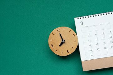close up of calendar and clock on the green table background, planning for business meeting or travel planning concept