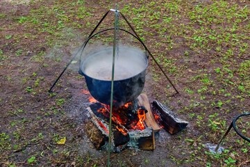 Traditional Outdoor Cooking with Firewood and Pot. Medieval Style Camp Cooking in the Forest. Open...