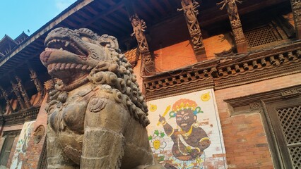 Fototapeta premium Lion Statue Guarding Temple at Patan Durbar Square, UNESCO World Heritage Site in Nepal