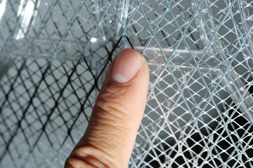 Finger touching electric mosquito swatter, electrical safety concept