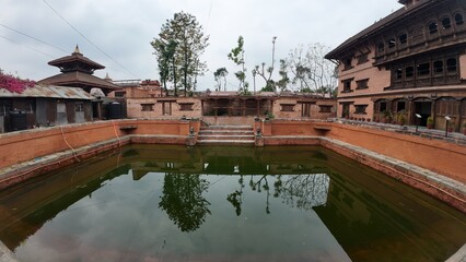 Naklejka premium Tranquil Waters of the Heritage Pond at the National Art Gallery, Housed in Bhaktapur's Former Royal Palace, Nepal