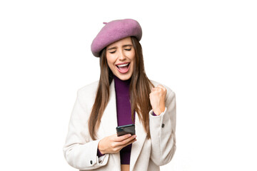 Young beautiful woman over isolated chroma key background with phone in victory position