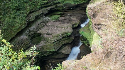 Obraz premium Serene Water Flow Through Mossy Rock Formations: A Natural Wonder in the Heart of Nepal