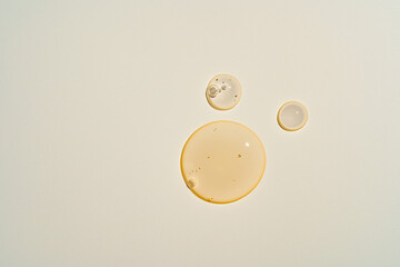 Morning dew-like serum droplets on warm beige, creating a fresh 'just-applied' look for natural beauty brands and skincare tutorials
