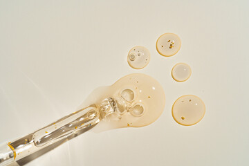 Top-view mockup of a glass dropper bottle with cosmetic pipette on trendy beige backdrop. Harsh...