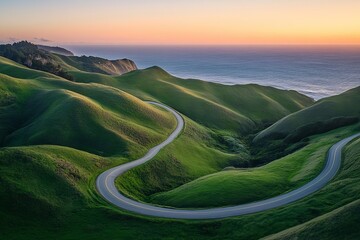 Winding coastal road through green hills at sunset with ocean view