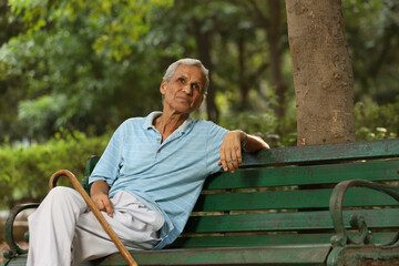 Indian old man spending leisure time at park 
after retirement