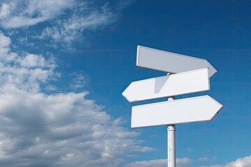 Three blank white directional signs on a post against a partly cloudy blue sky