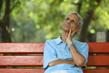 Portrait of a indian deep thinking old man at park