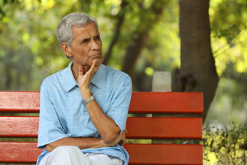 Portrait of a indian deep thinking old man at park
