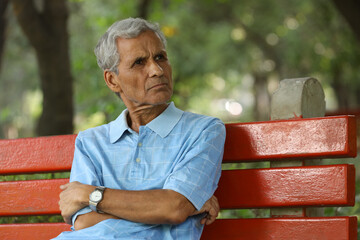 Portrait of a indian deep thinking old man at park