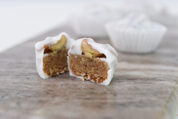 Classic White Chocolate Covered Cashew Butter Truffle Halves on Marble side view of Sweet Dessert Treat