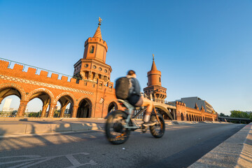 Oberbaum Bridge with soft sunset light and blurry cyclist in motion in Berlin. Germany