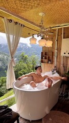 Handsome Man Relaxing in Bubble Bath with Stunning Mountain Sunset View