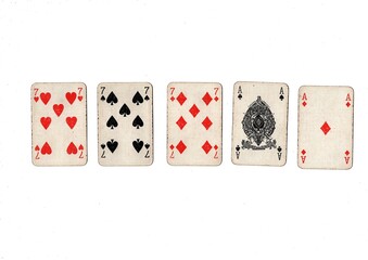 A poker hand of old grubby playing cards isolated on a white background.