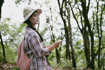 Young female traveler with backpack walking in national park or forest. recreation sport in nature....