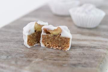 White Chocolate Covered Cashew Butter Truffle Halves isolated on Marble side view of Sweet Dessert Treat